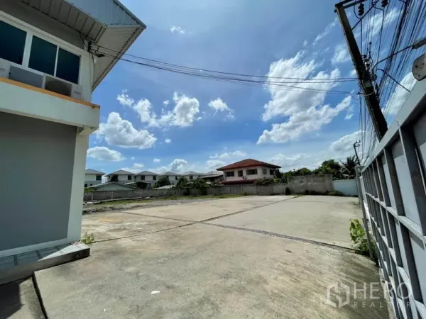 Warehouse for rent in Bang Kapi, Bangkok - Expansive concrete yard inside a fenced compound beside the warehouse, suitable for parking and loading.