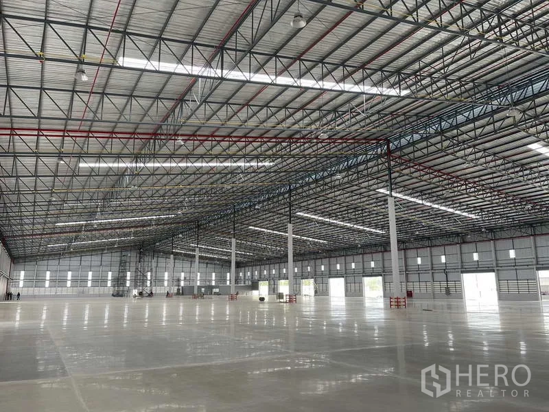 Factory for rent in Si Racha, Chon Buri - Large clear‑span factory floor with roof skylight panels and perimeter windows.