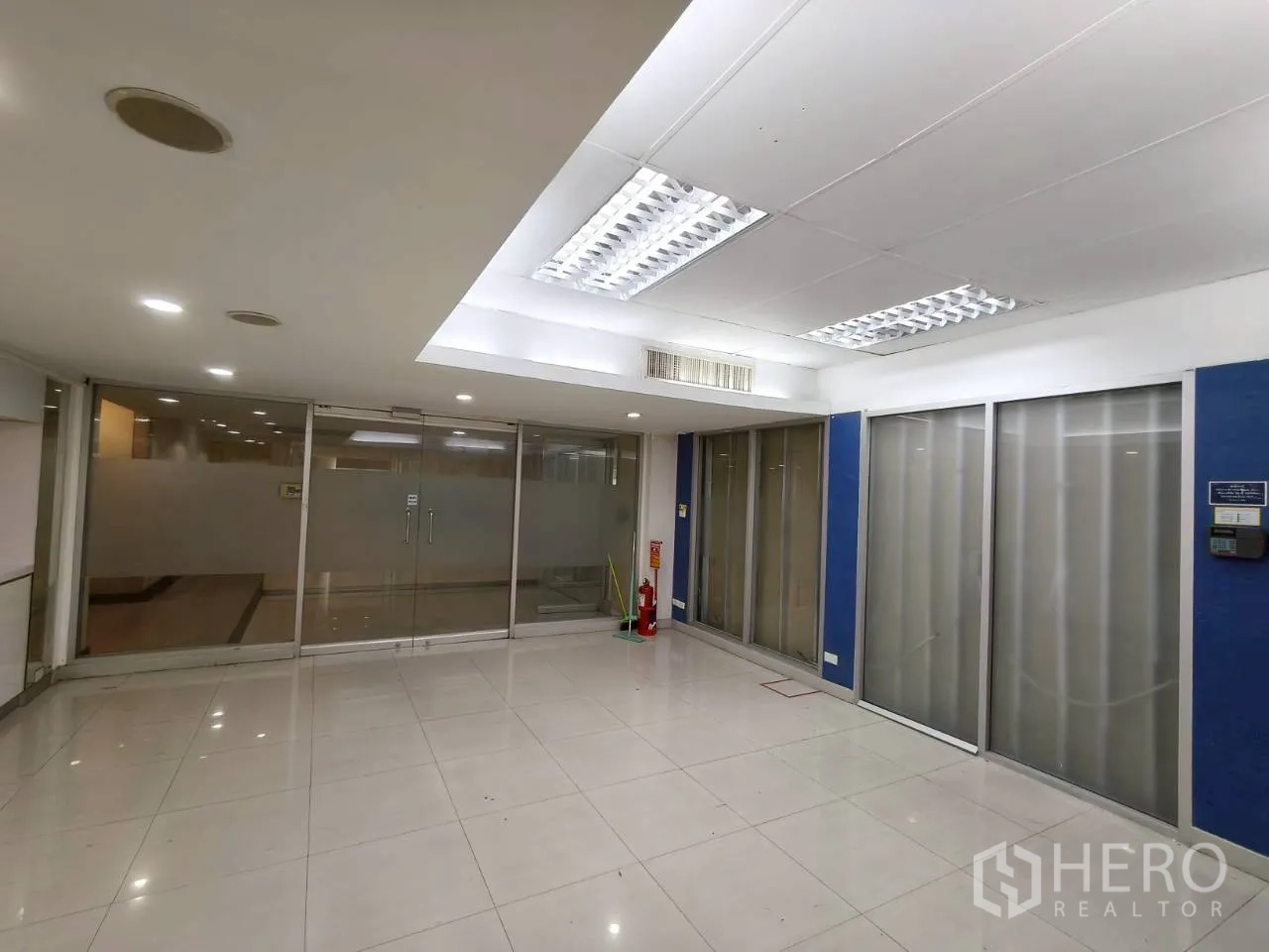 Office Space for rent in Chatuchak, Bangkok - Bright meeting area with frosted glass panels, blue accent walls and ceiling light panels.