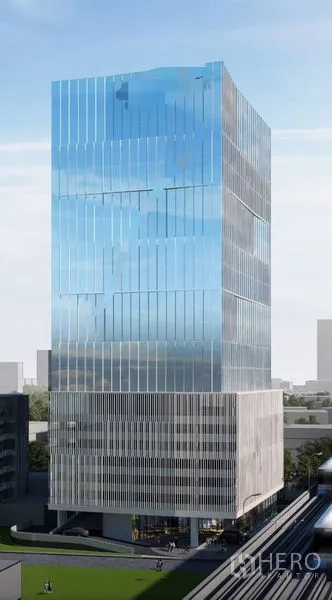 Office Space for rent - Contemporary glass-clad office tower exterior reflecting the sky near mass transit tracks.