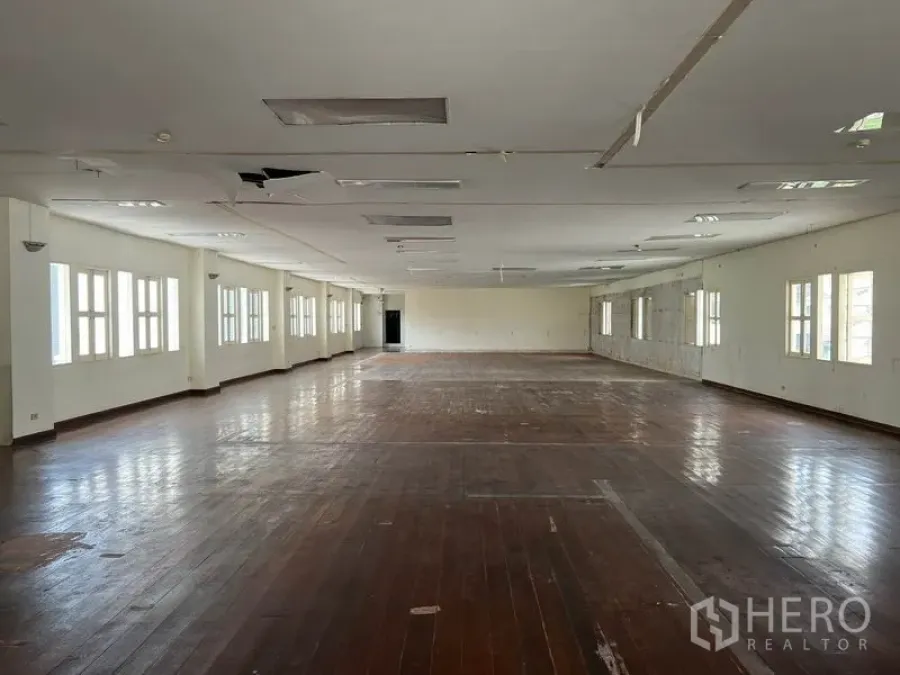 Office Space for rent in Khlong Toei, Bangkok - Spacious open-plan office floor in Phra Khanong with hardwood floors, white walls, and long rows of windows providing natural light.