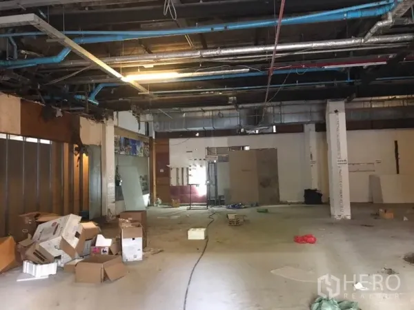 Retail Space for rent in Khlong Toei, Bangkok - Large shell retail space with high ceiling, visible ductwork and scattered packing boxes ready for fit-out.