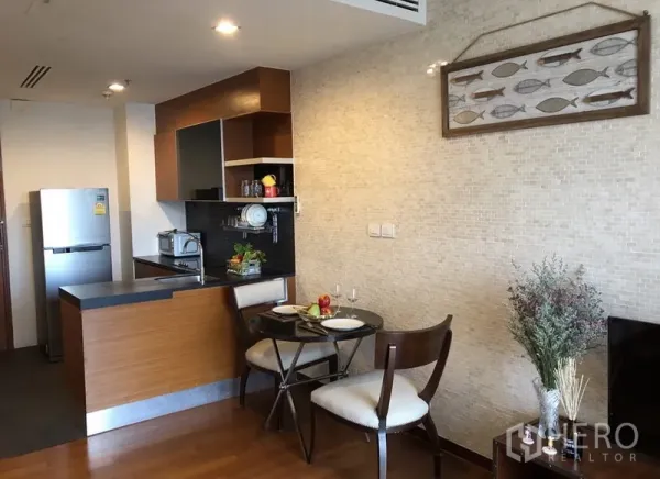 Condominium for rent in Khlong Toei, Bangkok - Open-plan kitchen with wooden cabinets, breakfast bar and a small dining set in a modern condo.