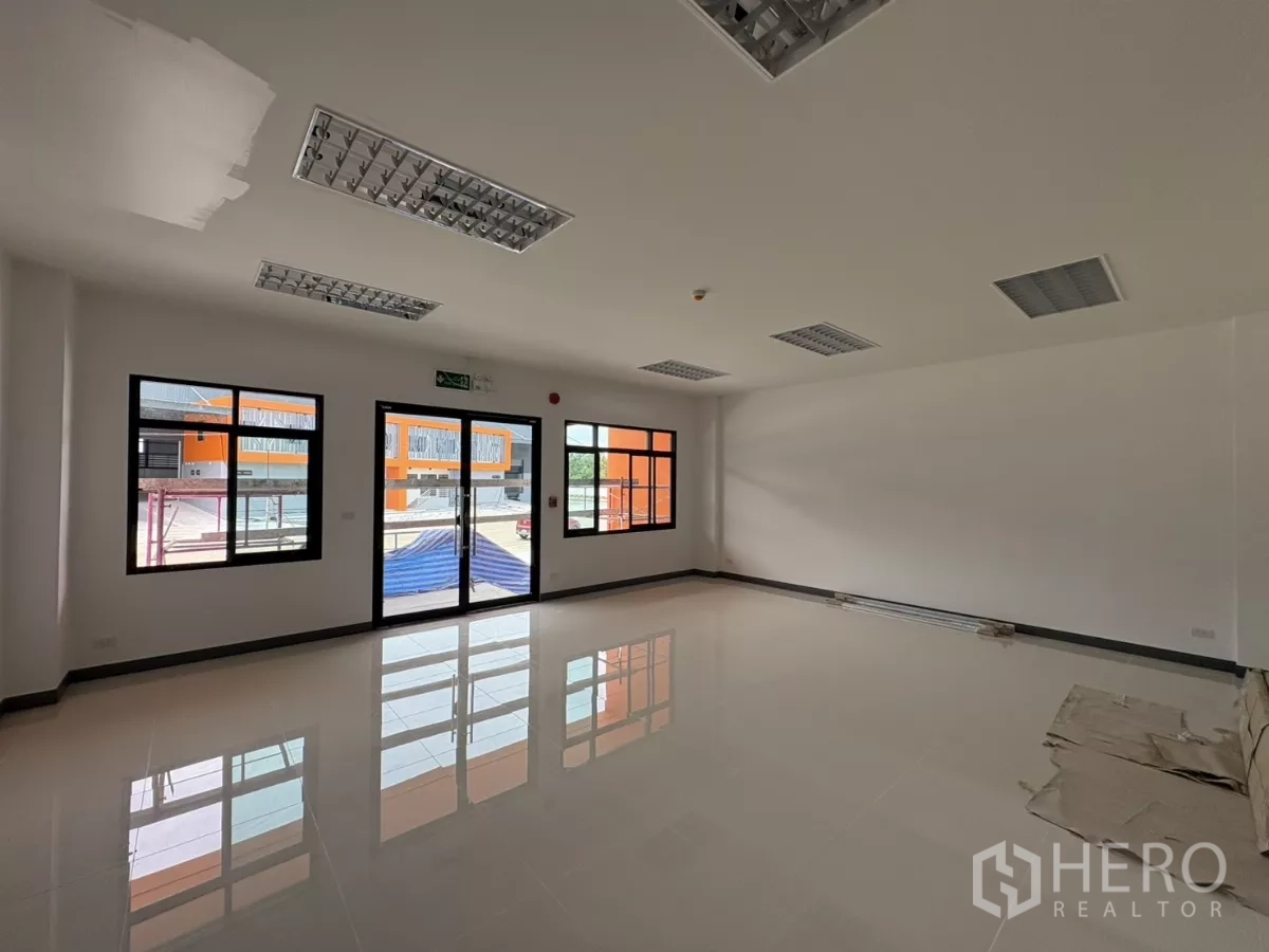 Factory for rent in Bang Pakong, Chachoengsao - Bright ground-floor office with tiled flooring, grid ceiling lights and glass doors and windows.