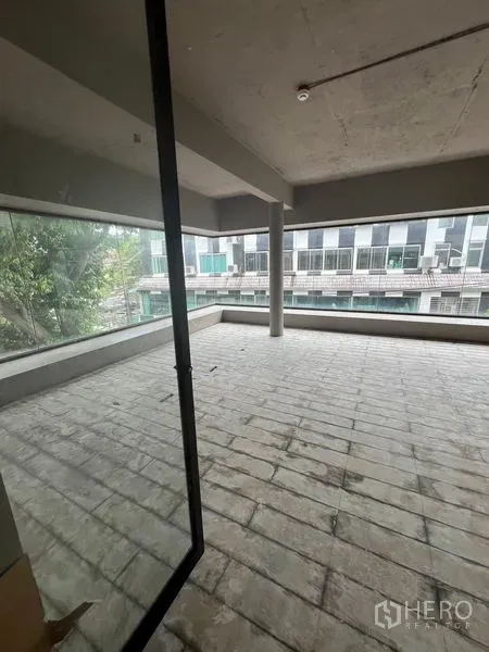 Retail Space for rent in Watthana, Bangkok - Open-plan interior with wraparound windows, center column and tiled floor.