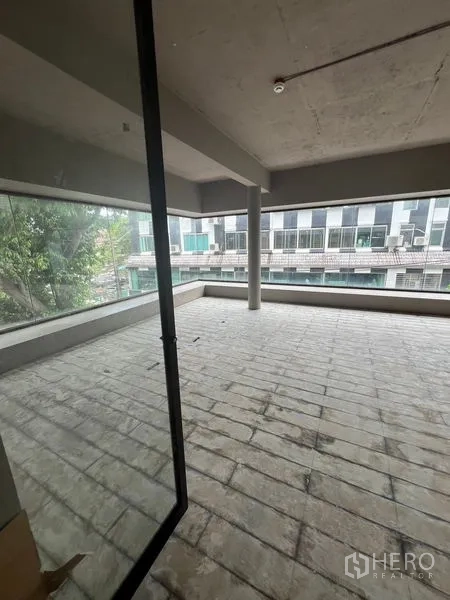 Retail Space for rent in Watthana, Bangkok - Open-plan interior with wraparound windows, center column and tiled floor.