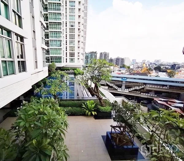 Condominium for rent in Khlong Toei, Bangkok - Condominium facility deck with landscaped garden, swimming pool and view of the BTS line nearby.