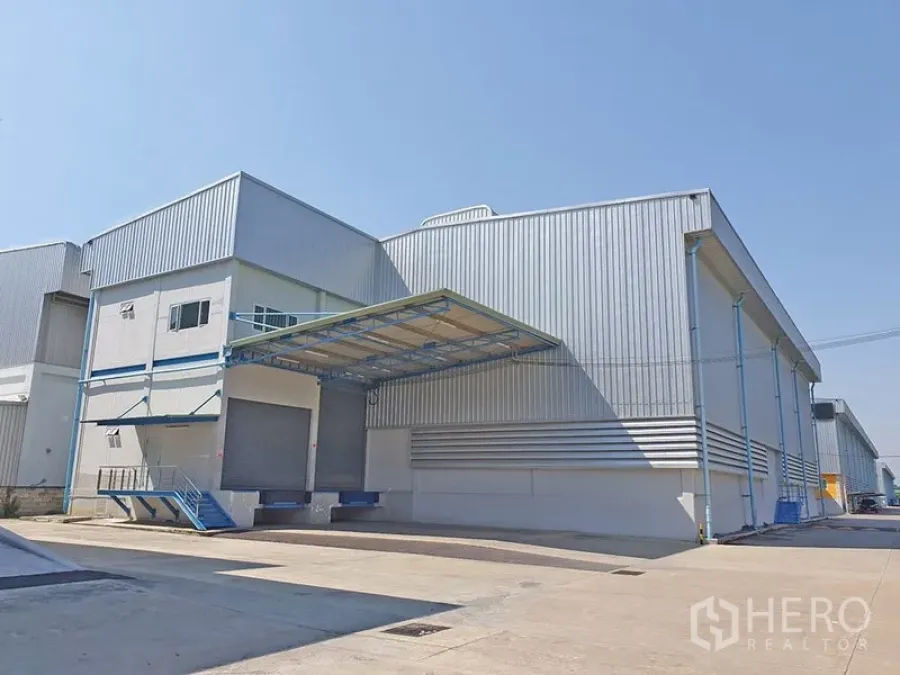 Warehouse for rent in Lat Krabang, Bangkok - Modern metal-clad warehouse exterior with covered loading bay and wide driveway in Lat Krabang, Bangkok.