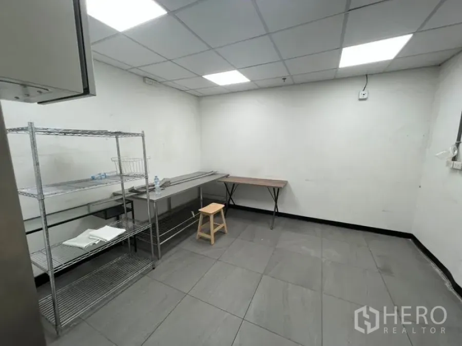 Retail Space for rent in Watthana, Bangkok - Back-of-house prep room with tiled floor, drop ceiling lights, stainless shelving and worktables inside Sukhumvit retail space.