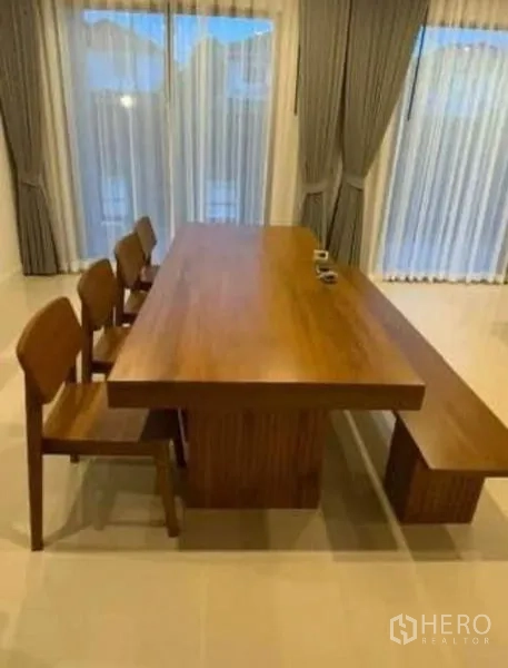独立式住宅 出租 - 实木餐桌配椅与长凳，旁为落地窗帘。
