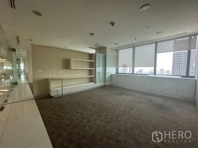 Office Space for rent in Khlong Toei, Bangkok - Private office with built-in shelving, carpet and windows with roller blinds.