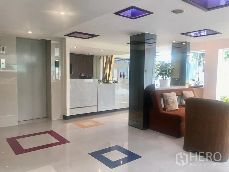 Shophouse for rent in Watthana, Bangkok - Bright lobby with marble reception, elevator and seating in a Sukhumvit shophouse