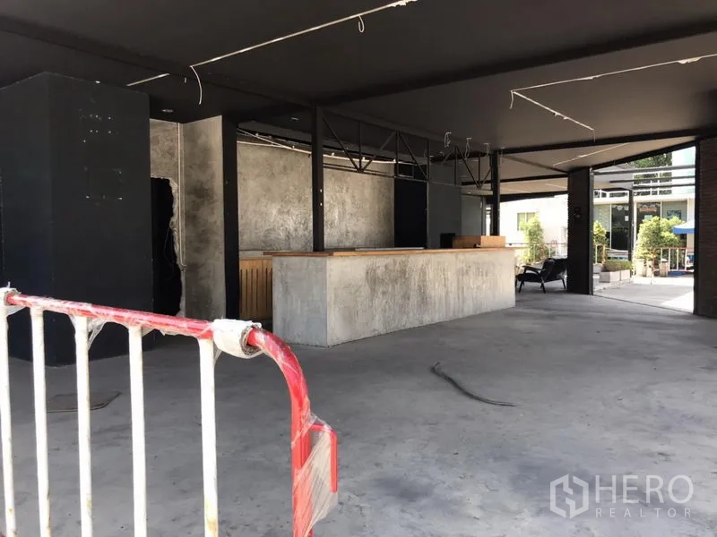 Retail Space for rent in Khlong Toei, Bangkok - Open-plan retail interior with concrete floor, long service counter and exposed ceiling structure.