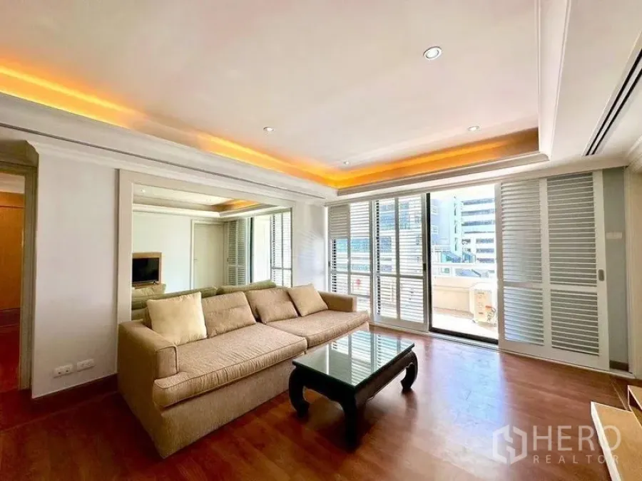 Condominium for rent - Living room angle showing mirrored wall, recessed lighting and balcony shutters.
