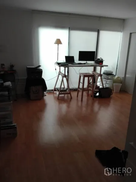 Condominium for rent in Khlong Toei, Bangkok - Quiet home office with standing desk, frosted floor-to-ceiling windows and wood floors.