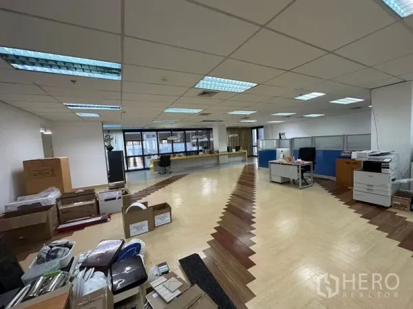 Office Space for rent in Khlong Toei, Bangkok - Open office area with partitioned workstations, copier and long counter, brightly lit by wall-to-wall windows.