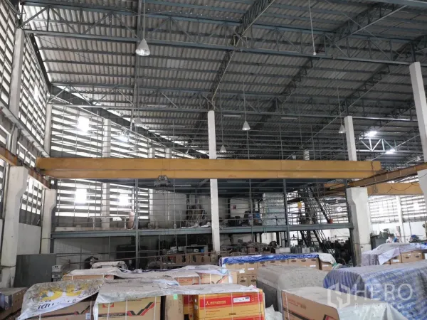 Factory for rent or sale in Bang Khun Thian, Bangkok - Warehouse interior showing yellow overhead crane beam, mezzanine platform and stair access.