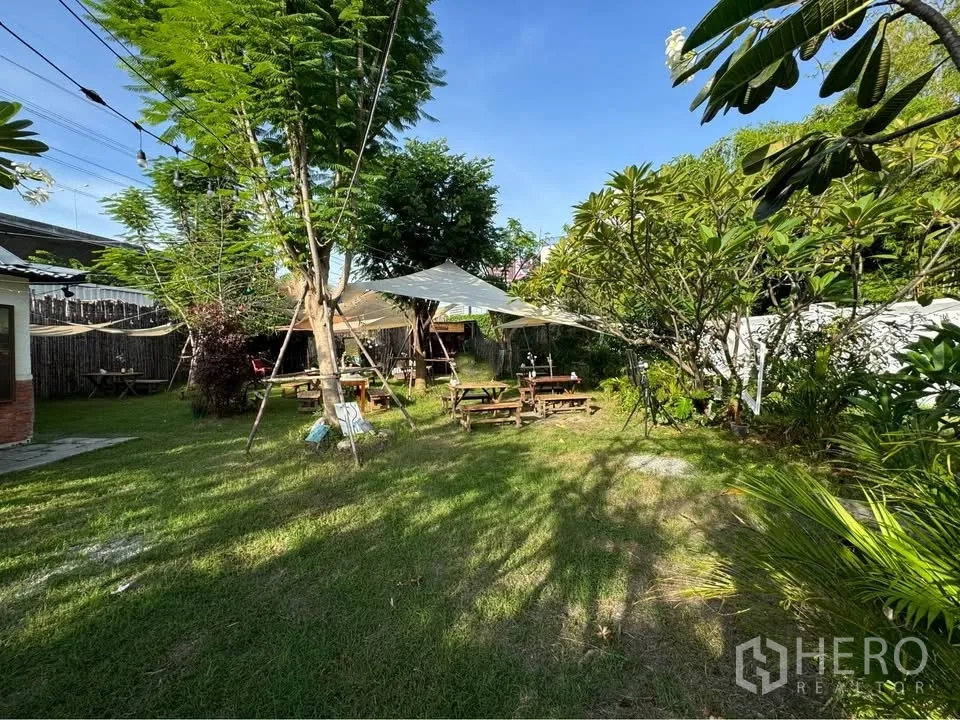 土地 for rent in Bang Na, Bangkok - 地块内的花园区域，配有野餐桌、遮阳篷与串灯。