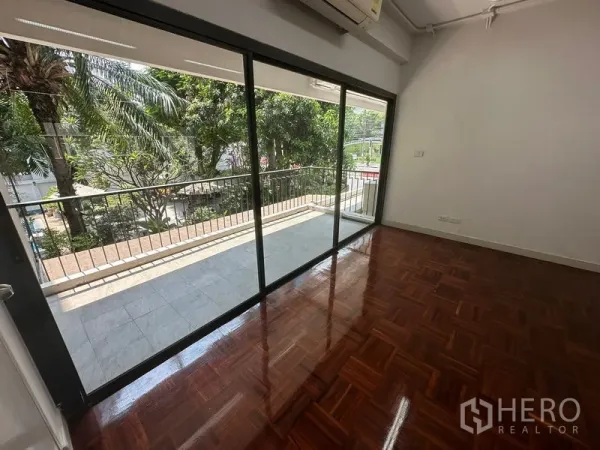 Office Space for rent - Private office room with large glass doors opening to a balcony overlooking greenery.