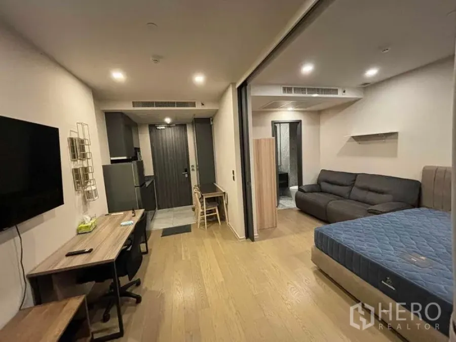 公寓 出租在Watthana, Bangkok - 开放式公寓内部，睡眠区与客厅、小厨房相连，木质地板。