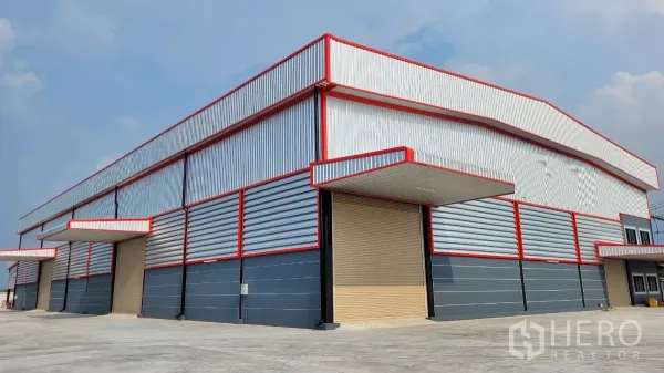 Factory for rent or sale in Phanat Nikhom, Chon Buri - Large warehouse facade with multiple roller shutter doors and sheltered bays.