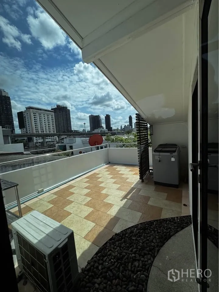 Townhouse for rent in Huai Khwang, Bangkok - Rooftop terrace with tiled floor and city skyline views.