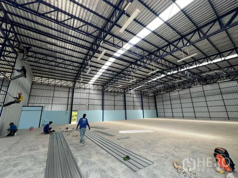 Warehouse for rent in Lat Krabang, Bangkok - Large column-free warehouse hall with high roof, metal panels and ample lighting with materials on the floor.