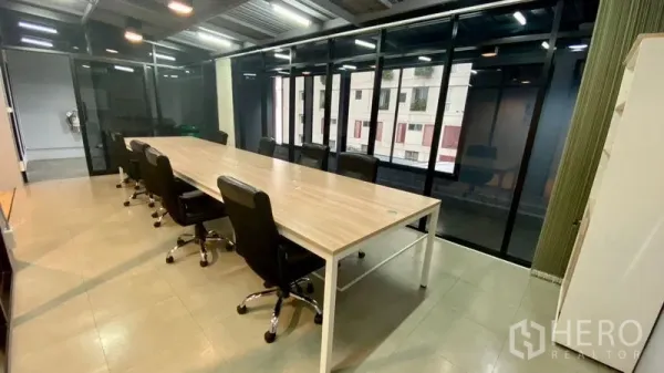 Office Space for rent in Sathon, Bangkok - Long conference table with executive chairs by floor-to-ceiling windows overlooking city buildings.