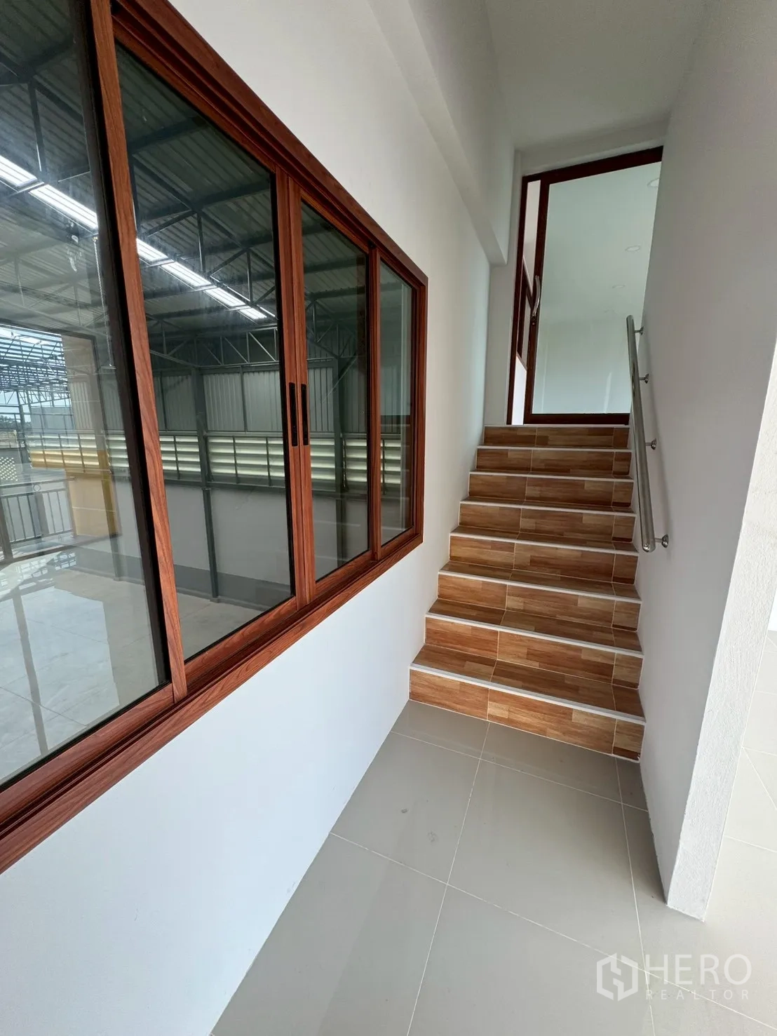 โรงงาน for sale in Mueang Samut Sakhon, Samut Sakhon - บันไดภายในข้างผนังกระจกยาวและขั้นบันไดลายไม้