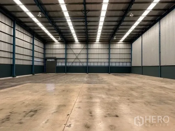 Factory for rent in Bang Phli, Samut Prakan - Spacious warehouse interior with a 12‑meter steel truss roof and polished concrete floor.