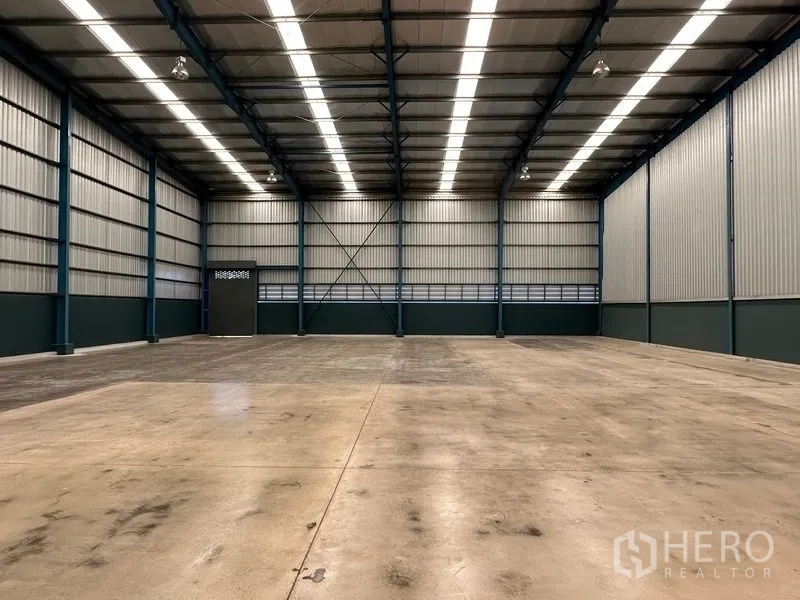 Factory for rent in Bang Phli, Samut Prakan - Spacious warehouse interior with a 12‑meter steel truss roof and polished concrete floor.