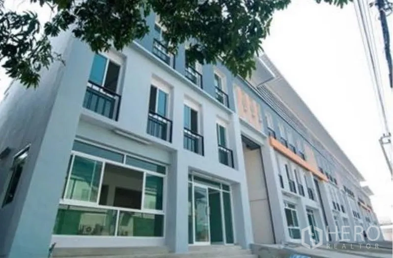 Factory for rent in Bang Sao Thong, Samut Prakan - Close-up of the industrial façade with glass storefronts and small balconies.