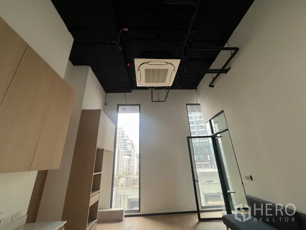 Retail Space for rent - High-ceiling showroom with tall windows, cassette air-conditioning, glass door and built-in wood cabinetry.