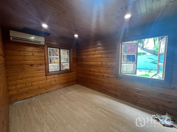 Home Office for rent in Suan Luang, Bangkok - Air-conditioned wood-paneled room with two windows and recessed lighting.