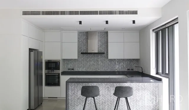 Townhouse for sale in Watthana, Bangkok - Contemporary white kitchen with herringbone tile backsplash, island breakfast bar and built-in appliances.