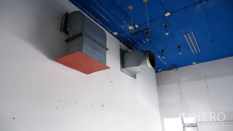 Retail Space for rent in Watthana, Bangkok - Close-up of exposed ventilation ductwork mounted on a high blue ceiling.