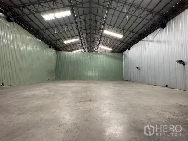 货栈 出租在Pak Kret, Nonthaburi - 高挑屋顶的仓库内景，钢桁架、明亮LED照明与耐用混凝土地面。