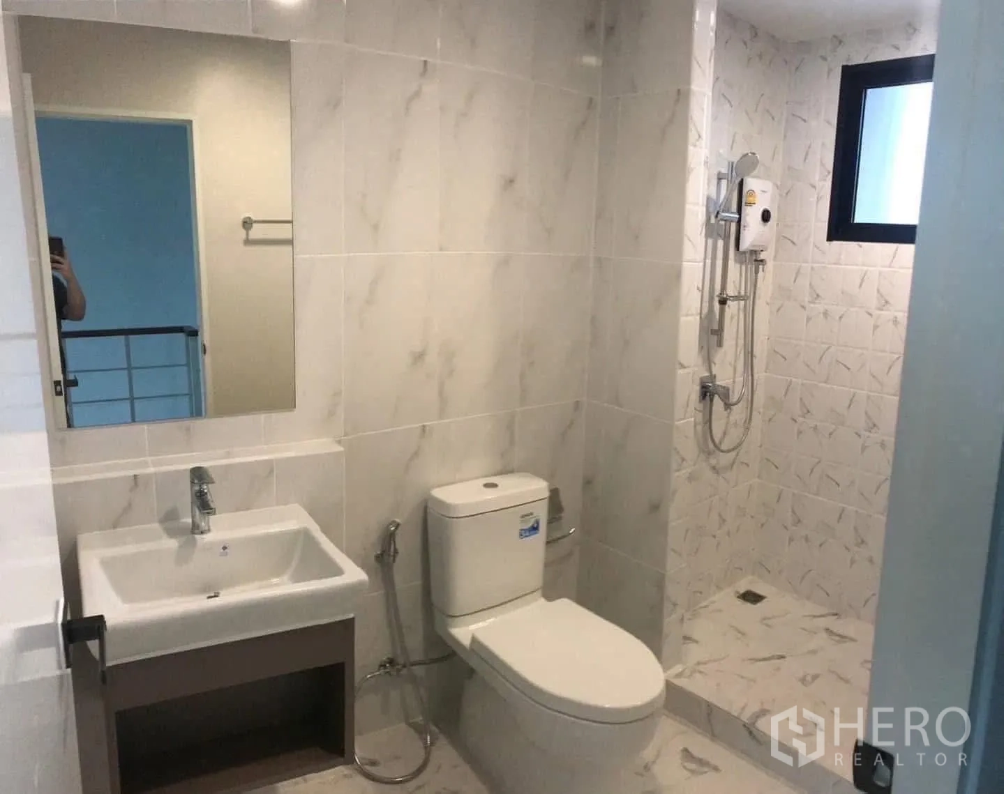 Townhouse for rent or sale in Prawet, Bangkok - Bathroom with vanity, toilet, shower zone and ventilation window.