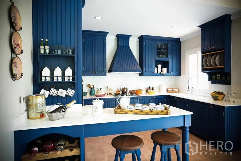 Detached House for rent in Bang Na, Bangkok - Spacious kitchen featuring deep blue cabinetry, white countertops, island breakfast bar and vented range hood.