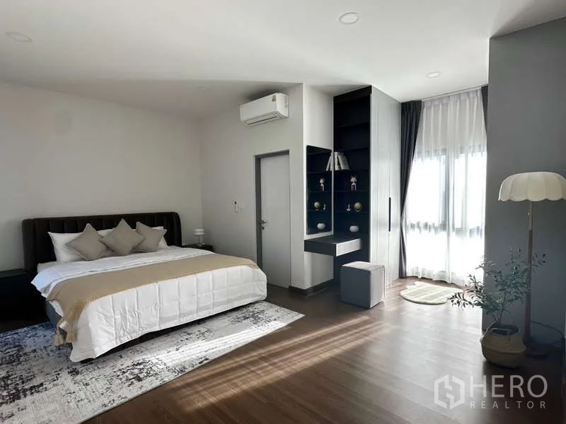 Detached House for rent in Bang Phli, Samut Prakan - Secondary bedroom with bed, built-in shelves, desk and floor-to-ceiling curtains.