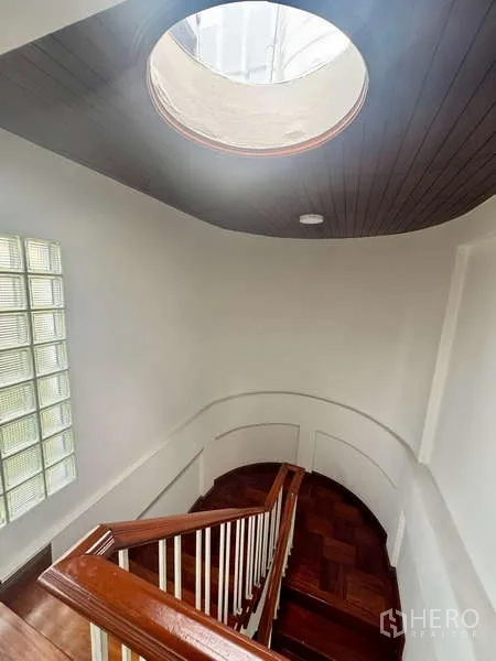 Office Space for rent in Bang Rak, Bangkok - Curved staircase with wooden handrail under a circular skylight and glass-block feature wall.