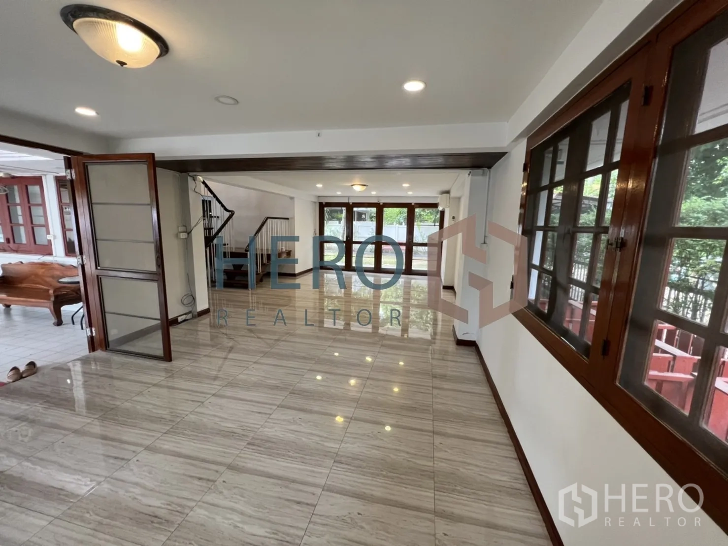Detached House for rent in Watthana, Bangkok - Long living hall opening to the terrace with folding wooden doors and stair access.