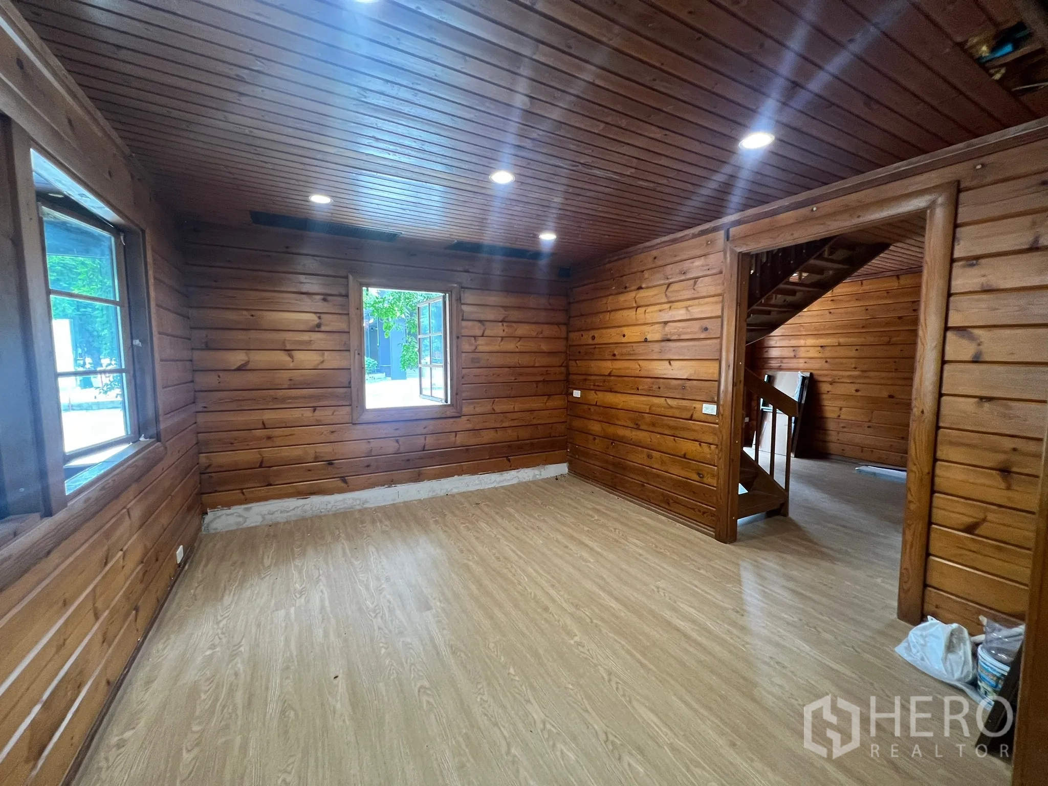 Home Office for rent in Suan Luang, Bangkok - Ground-floor wood-paneled room with open windows and a staircase entry.