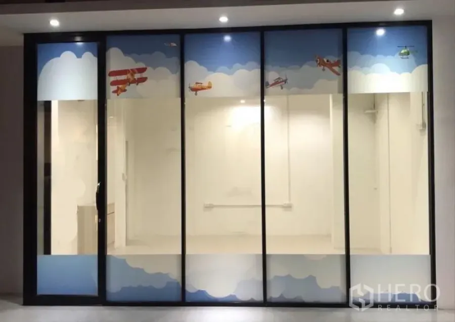 Office Space for rent in Watthana, Bangkok - Glass-fronted office unit with playful airplane decals and bright lighting in Watthana, Bangkok.