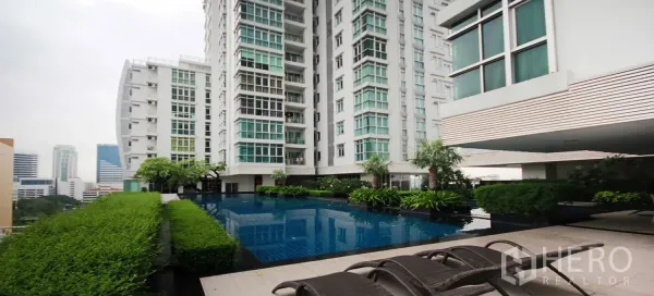 Condominium for rent in Khlong Toei, Bangkok - Condominium pool deck with sun loungers, lush landscaping and city views.