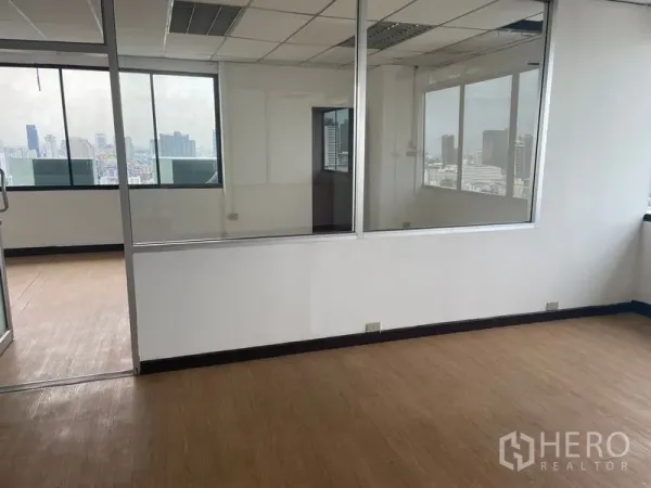 Office Space for rent in Din Daeng, Bangkok - Open-plan office area with interior glass walls and panoramic windows overlooking the Bangkok skyline.