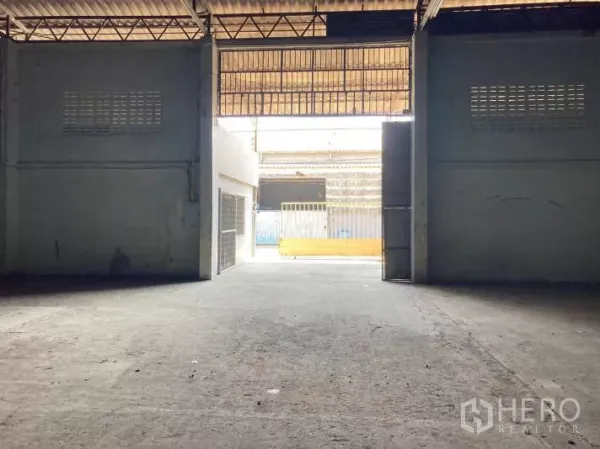 Factory for rent in Bang Sao Thong, Samut Prakan - View from warehouse interior toward wide sliding entrance for truck access.