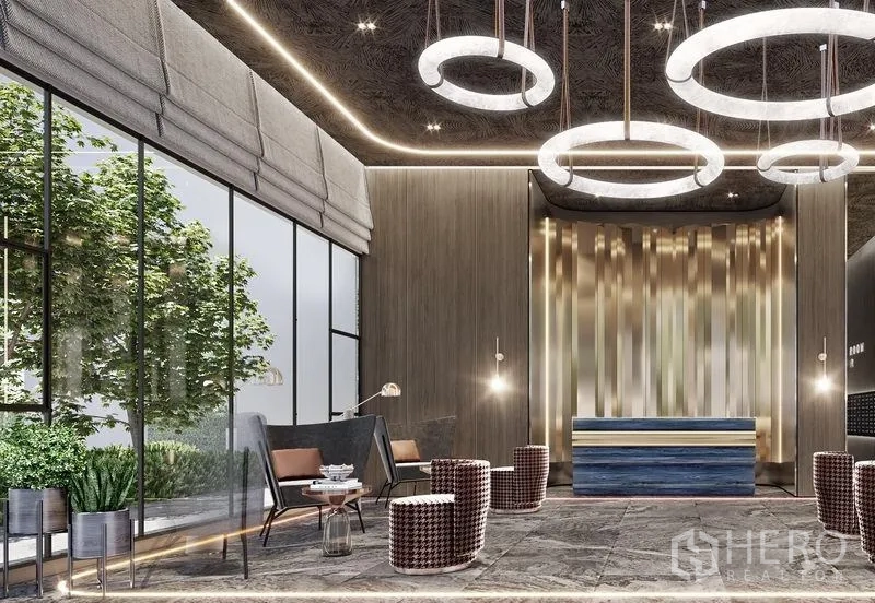 Condominium for sale in Khlong Toei, Bangkok - Luxurious condo lobby with circular chandeliers, floor‑to‑ceiling windows and lounge seating in Khlong Toei, Bangkok.