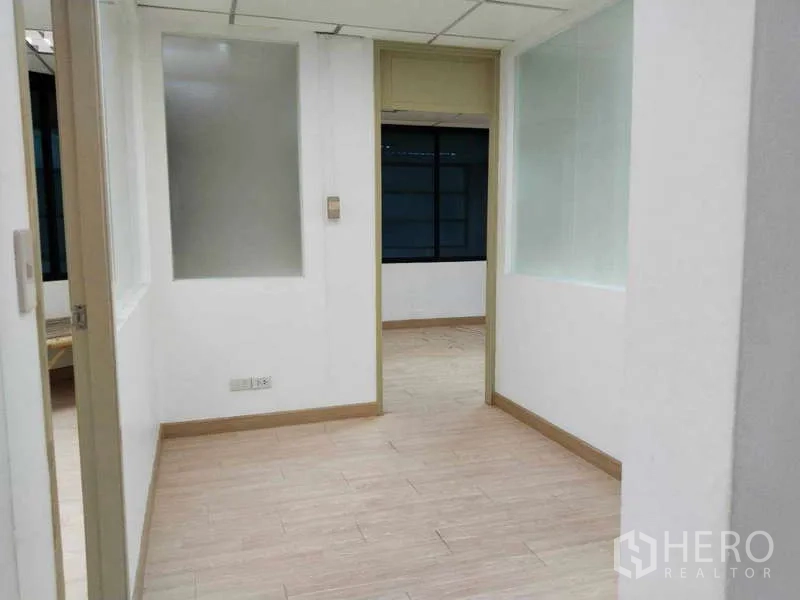 Office Space for rent in Bang Na, Bangkok - Entry corridor into enclosed offices with interior glass panels and wood floors.