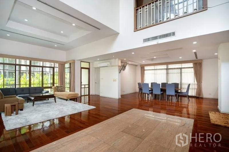 Detached House for rent in Watthana, Bangkok - Open-plan living area with floor-to-ceiling windows and adjacent dining zone.